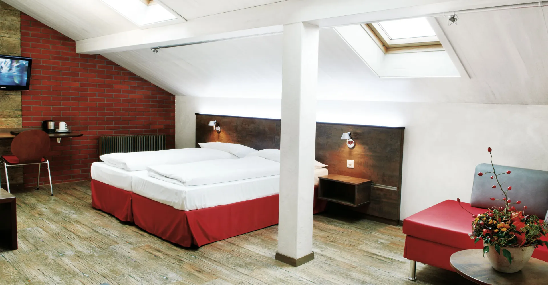 Sorell Hotel Arabelle Dreibettzimmer mit Sitzecke und Schreibtisch