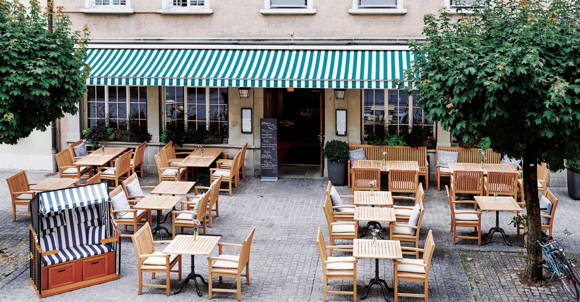 Terrasse mit Tischen und Stühlen vor dem Hotel Krone