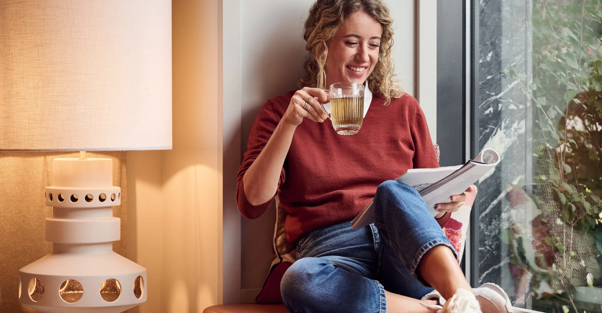 Woman sitting at the window drinking tea
