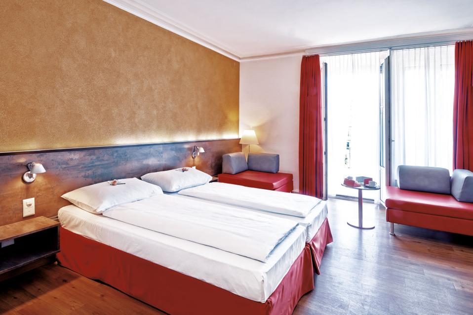 Sorell Hotel Arabelle Zweibettzimmer mit Sitzecke und Schreibtisch