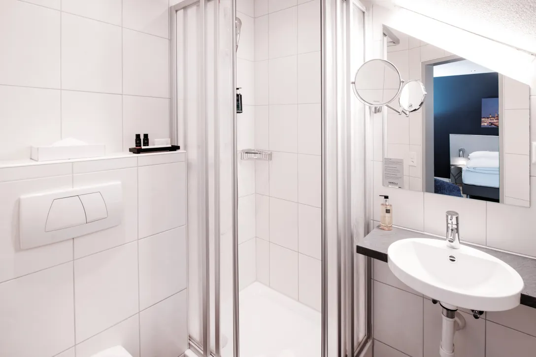 Sorell Hotel Rex Standard Einzelzimmer Badezimmer mit Dusche mit Sitzecke und Schreibtisch