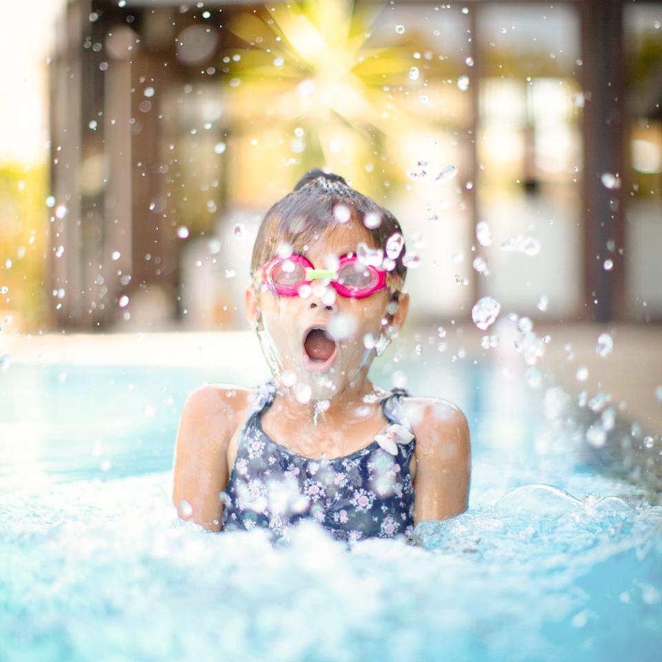 kleines Mädchen mit Taucherbrille im Schwimmbad