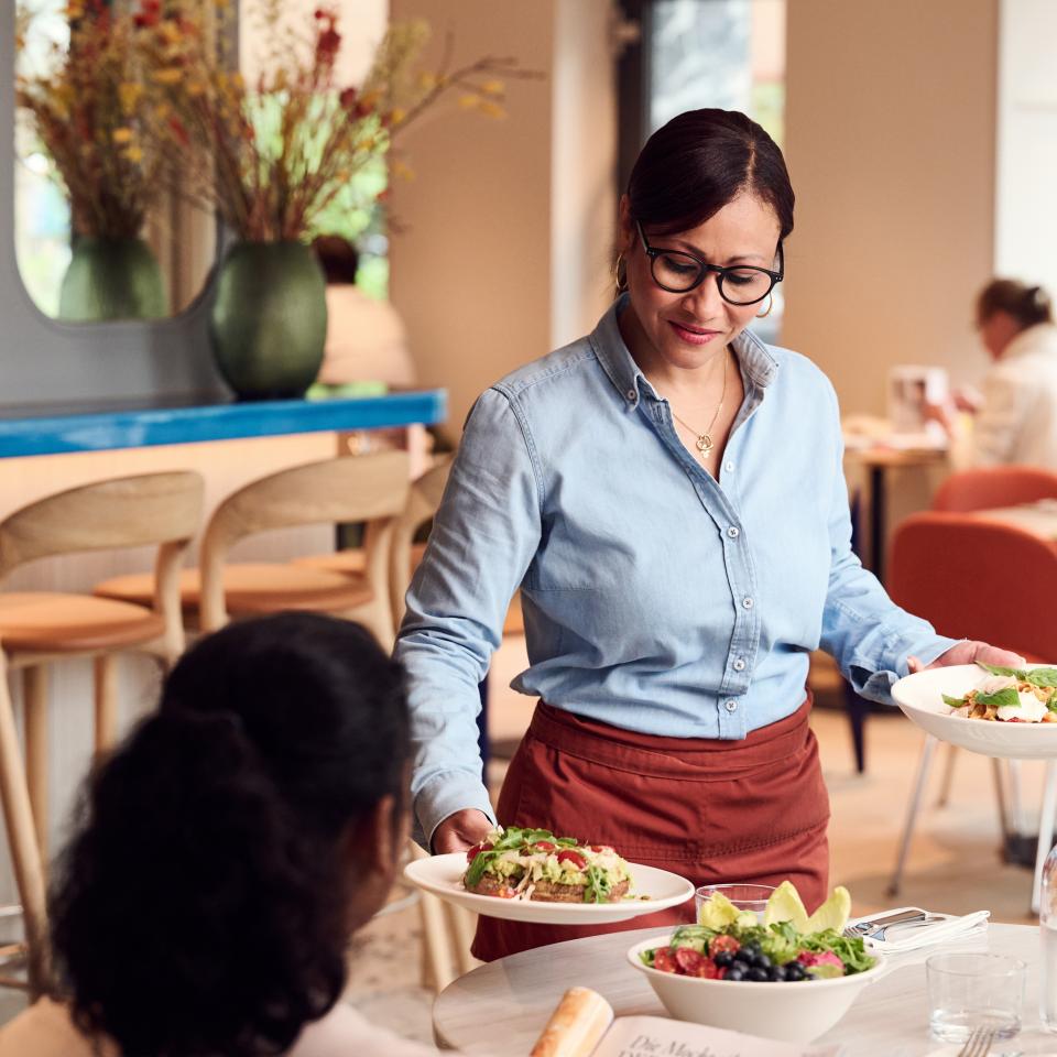 Serviceangestellte serviert das Essen