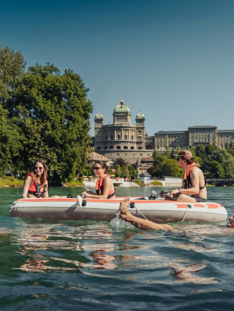 Menschen auf der Aare vor dem Bundeshaus auf Gummibooten