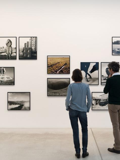 Personen schauen Fotografien in einem Museum an